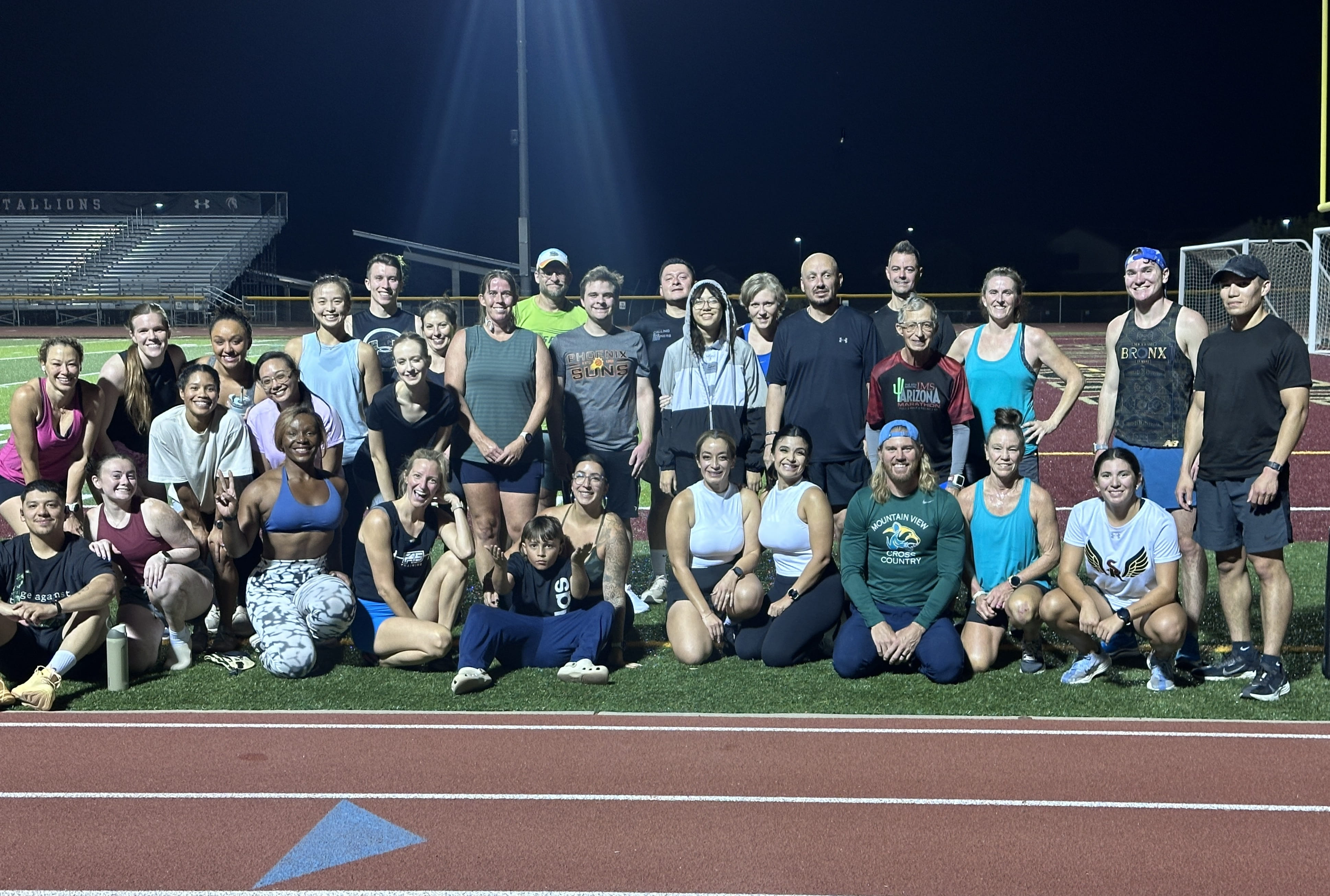 three runners posing on red track ready to start